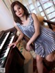 A woman in a silver dress sitting at a piano.