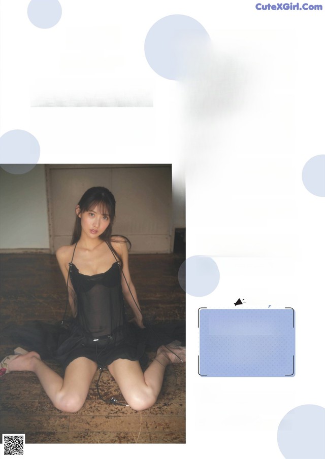 A woman in a black dress sitting on the floor.