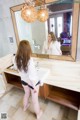 A woman standing in front of a mirror in a bathroom.